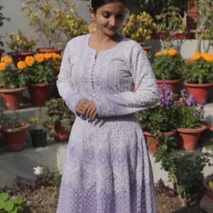 Woman in purple dress among flowers.