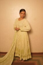 Woman in elegant traditional light green attire.