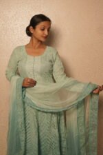 Woman in elegant light green attire.